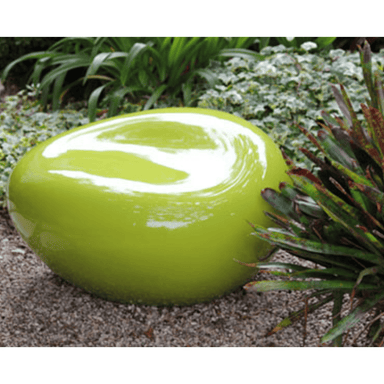 Green fiberglass pebble garden seat on a gravel surface surrounded by plants