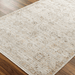 A Light brown machine woven outdoor rug with geometric pattern placed on a wooden floor