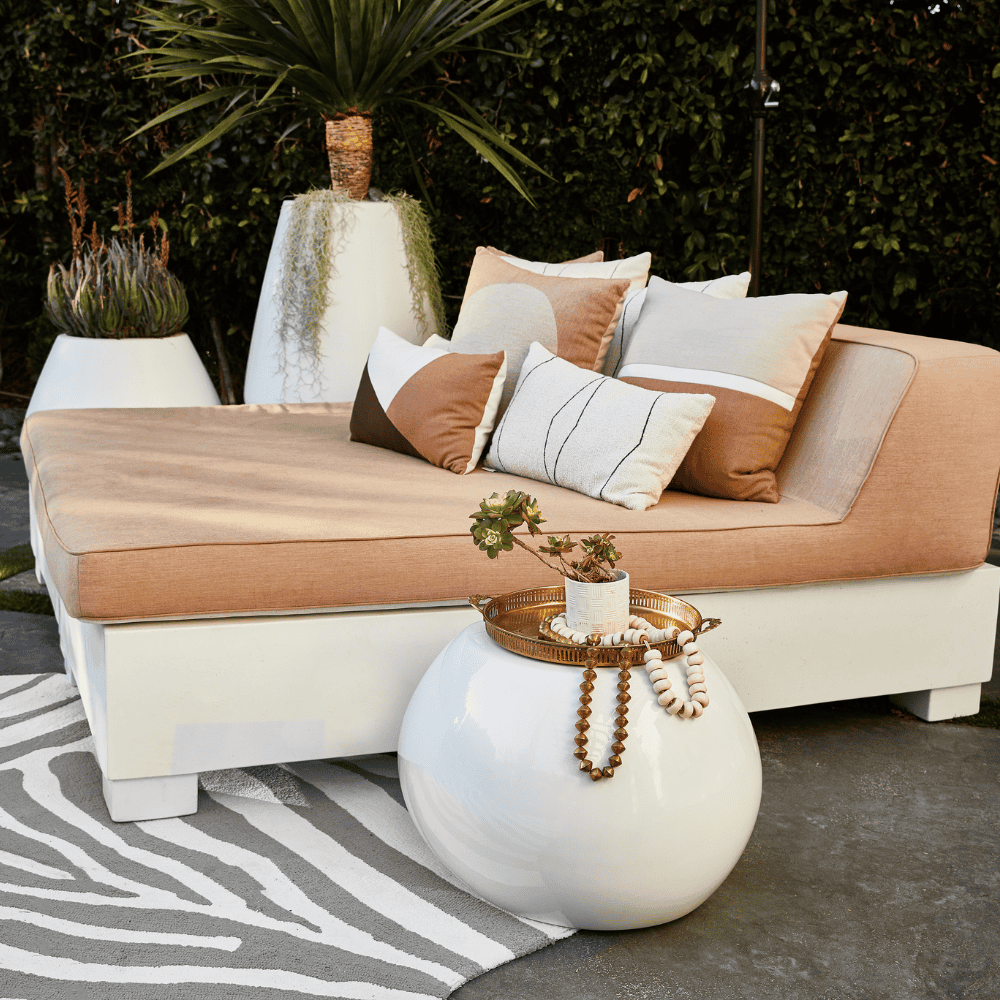 white outdoor concrete urn placed on the patio together with large sun bed and white outdoor concrete planter 