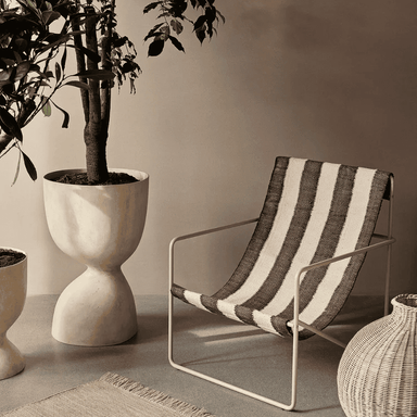 modern striped outdoor lounge chair with steel frame placed beside potted plant in a cozy setting