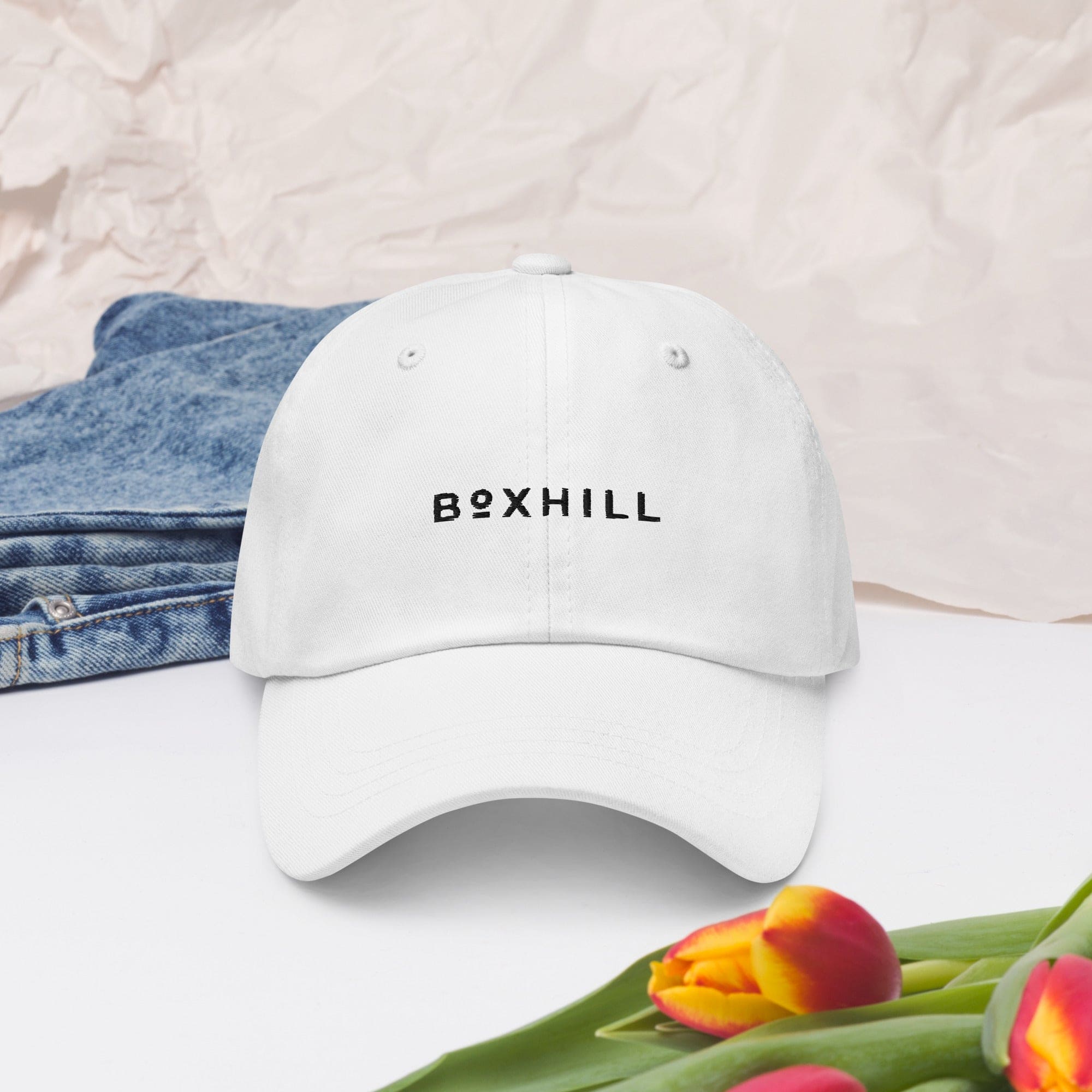Boxhill's Minimalist White Hat with jeans and plain back ground