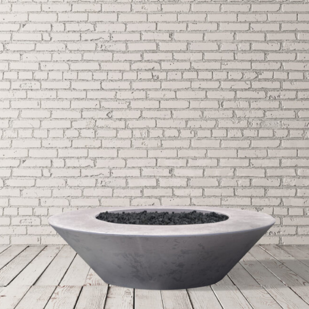 Grey outdoor round concrete fire bowl placed on a wooden deck against white brick wall