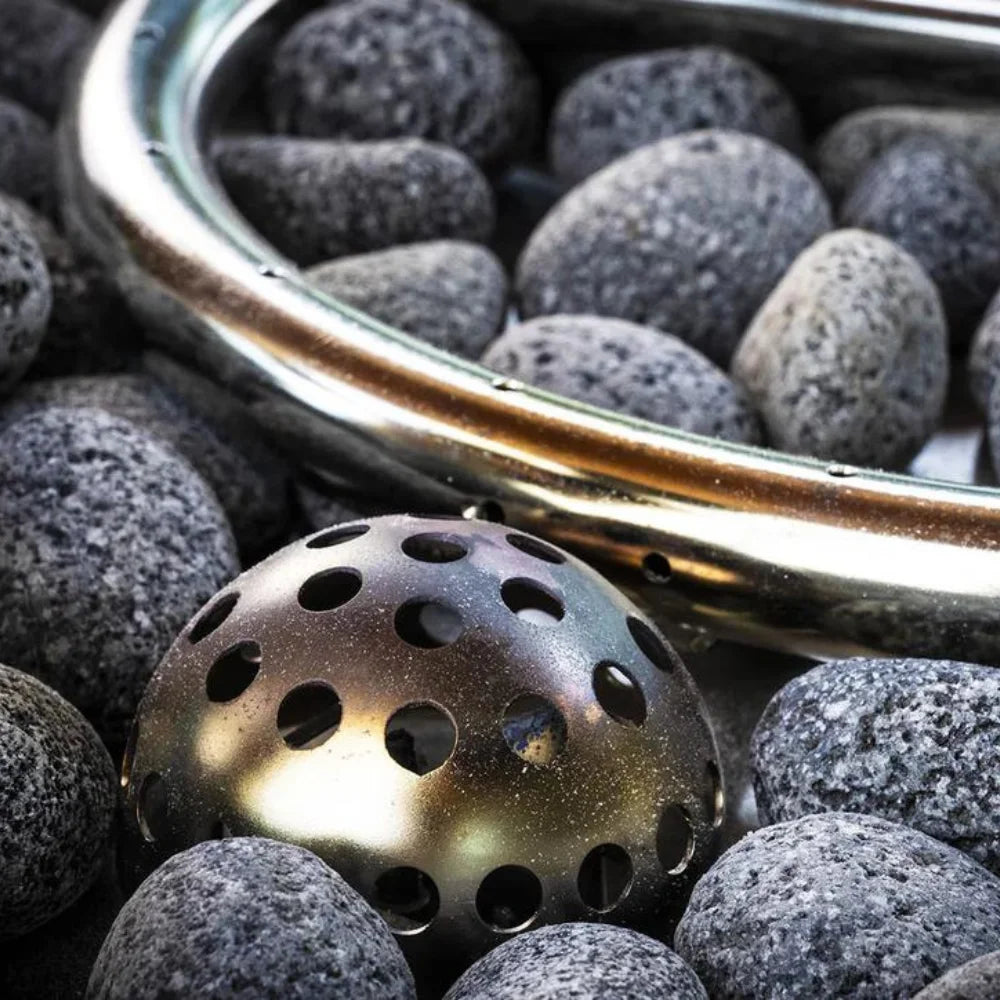 Close-up view of hidden propane tank fire pit with metal sieve and lava rocks
