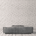 Grey concrete rectangular fire pit table placed on a wooden deck against white brick wall