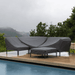 A set of outdoor sofa and chairs beside the pool covered by dark gray patio seat covers