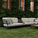 A beige left corner lounge sofa with black aluminum frame and beige outdoor ottoman set on a lawn surface patio