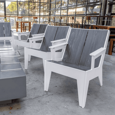 Four White outdoor lounge armchair with gray wood grain backrest and seat placed in an indoor seating area with glass wall