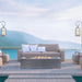 An outdoor seating area featuring a gray outdoor concrete rectangular fire pit  in front of a beige outdoor sofa with pillows