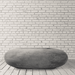 Grey pebble outdoor concrete oval fire table placed on a wooden deck beside white brick wall