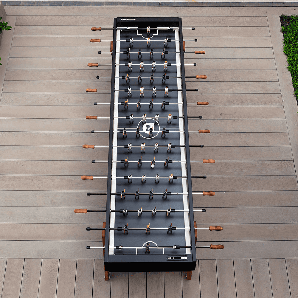 Top view of a black outdoor football table placed on a wooden deck