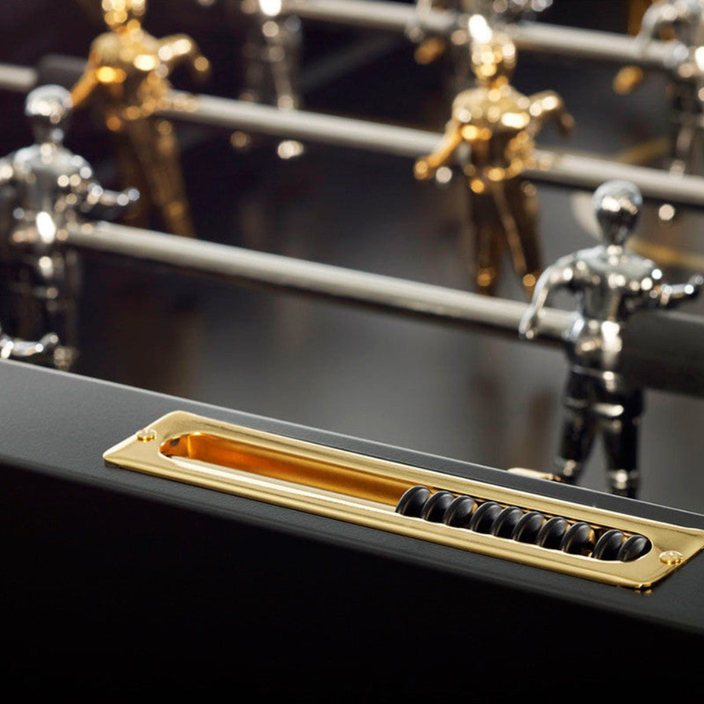 Close up view of a luxurious black outdoor football table shows a gold score counter